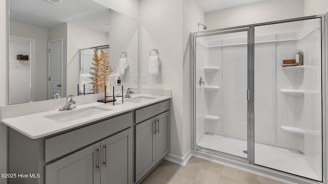 bathroom featuring double vanity, a sink, and a shower stall