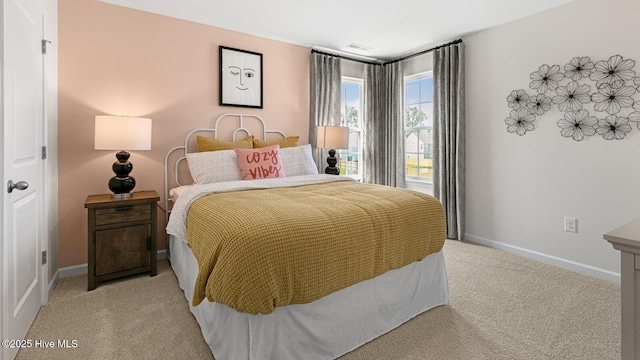 bedroom featuring light carpet and baseboards