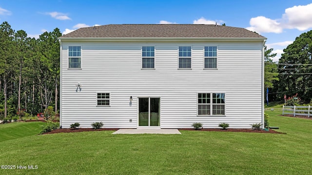 back of property with fence, a patio, and a yard