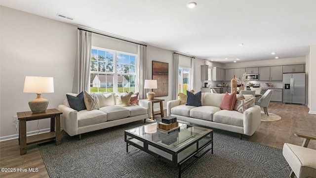 living area featuring recessed lighting, visible vents, baseboards, and wood finished floors