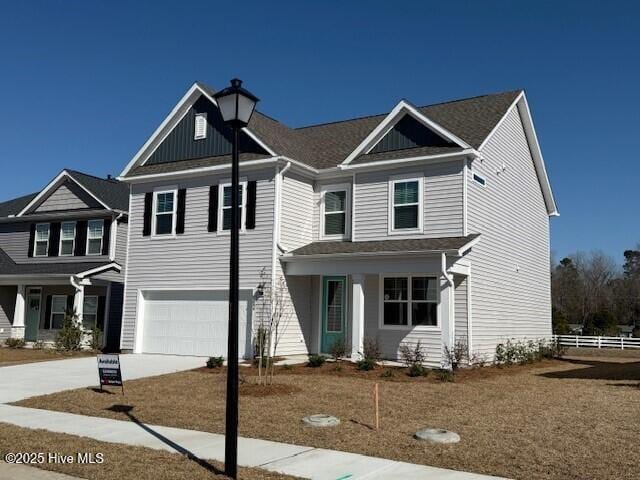 view of front of house featuring a garage, board and batten siding, concrete driveway, and fence