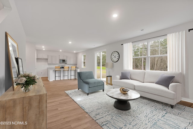 living area featuring recessed lighting, light wood-type flooring, baseboards, and visible vents