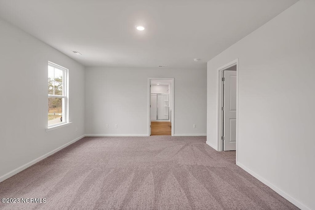 carpeted empty room featuring baseboards