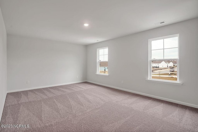 unfurnished room with recessed lighting, visible vents, carpet flooring, and baseboards