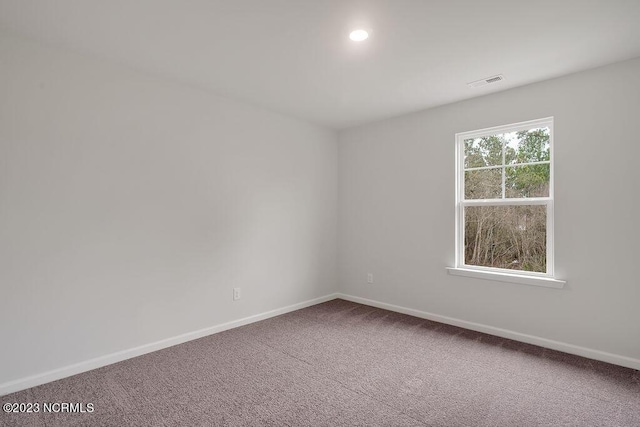 empty room featuring visible vents, recessed lighting, baseboards, and carpet