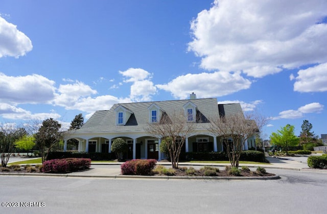 new england style home with covered porch and driveway