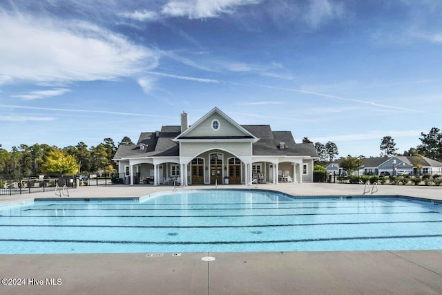 community pool with a patio and fence