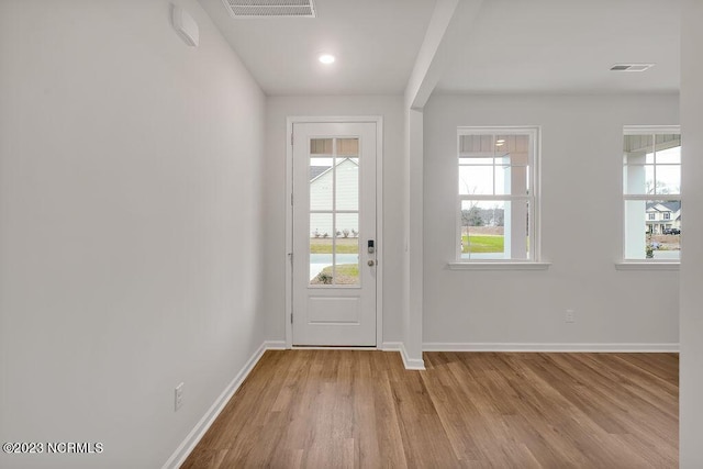 doorway featuring visible vents, baseboards, and wood finished floors