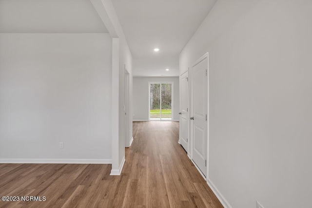 hall with recessed lighting, wood finished floors, and baseboards