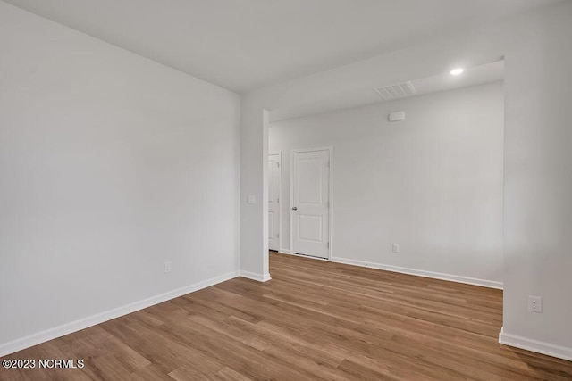 spare room featuring visible vents, wood finished floors, and baseboards