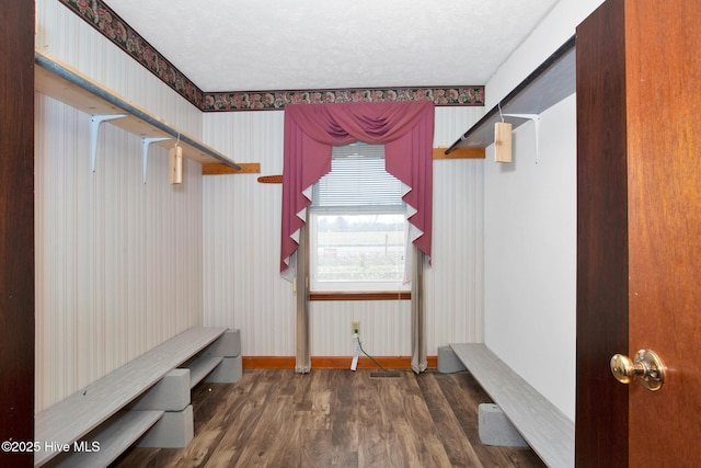 mudroom featuring wood finished floors, a textured ceiling, baseboards, and wallpapered walls