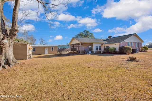 back of house featuring a sunroom and a yard