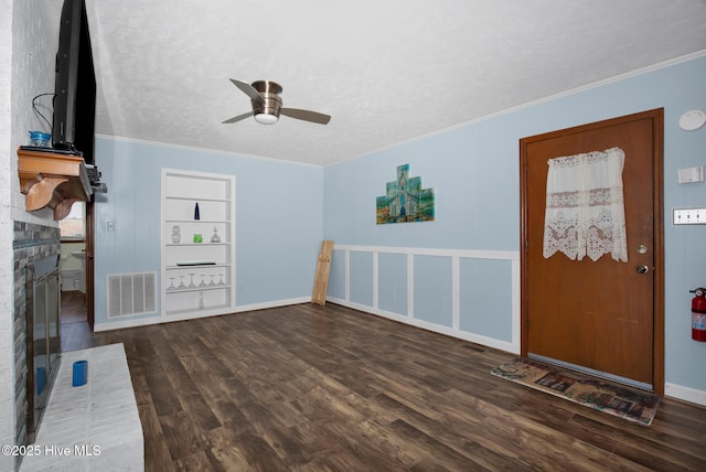 entrance foyer with crown molding, visible vents, ceiling fan, a textured ceiling, and wood finished floors