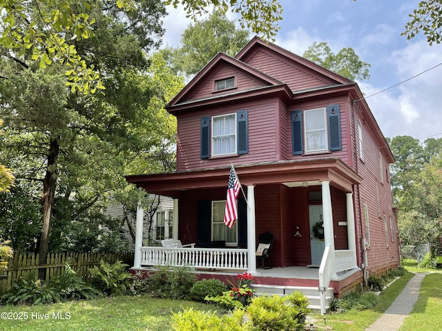 view of front of home featuring fence and a porch