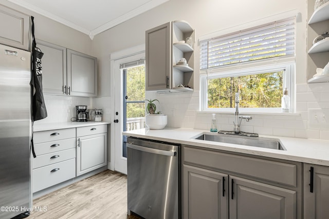 kitchen with ornamental molding, appliances with stainless steel finishes, gray cabinetry, open shelves, and a sink