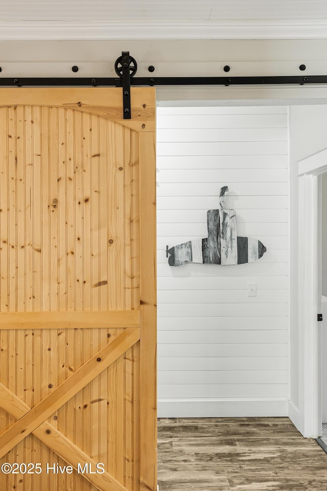 room details featuring a barn door and wood finished floors