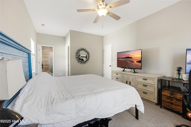 bedroom with light colored carpet, ceiling fan, visible vents, and ensuite bath