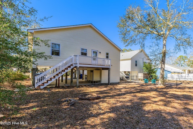 rear view of property featuring stairs, fence, and a wooden deck