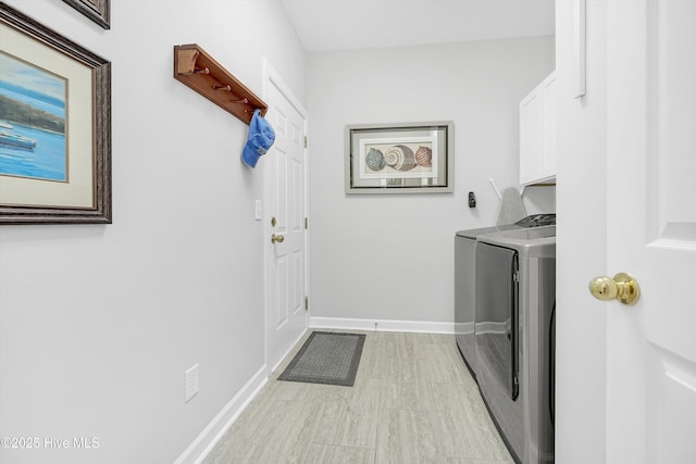 laundry area with cabinet space, independent washer and dryer, and baseboards