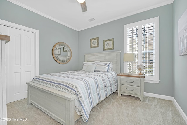 bedroom with baseboards, visible vents, light colored carpet, ornamental molding, and a closet