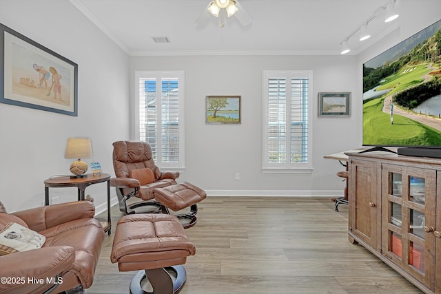 living area featuring light wood-style flooring, visible vents, ornamental molding, and baseboards