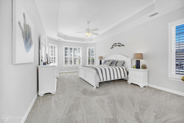 bedroom featuring carpet flooring, a raised ceiling, visible vents, and baseboards