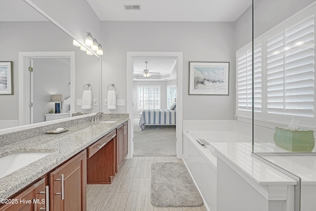 ensuite bathroom featuring a garden tub, double vanity, visible vents, a sink, and ensuite bath