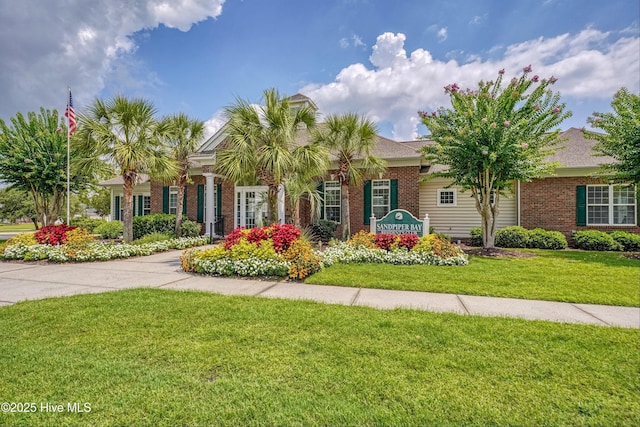 view of front of house featuring brick siding and a front lawn