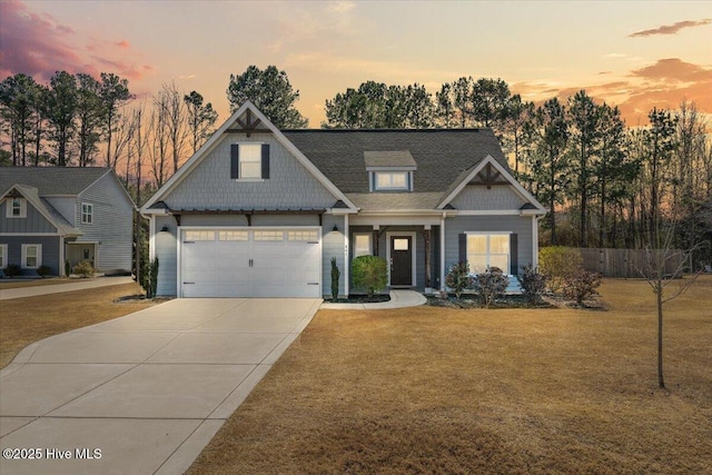 craftsman inspired home with a garage, concrete driveway, and a lawn