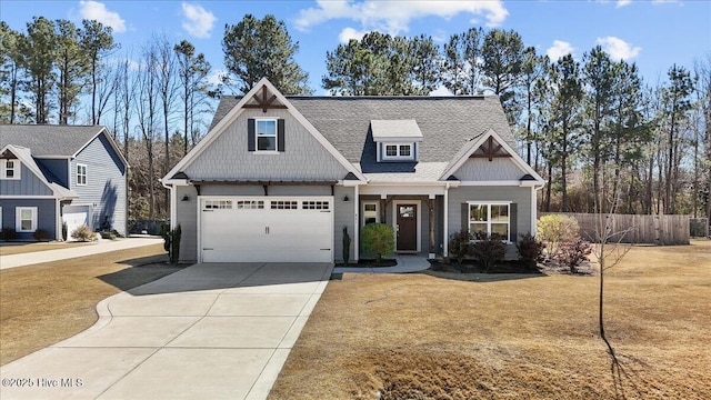 craftsman house featuring an attached garage, fence, driveway, roof with shingles, and a front lawn