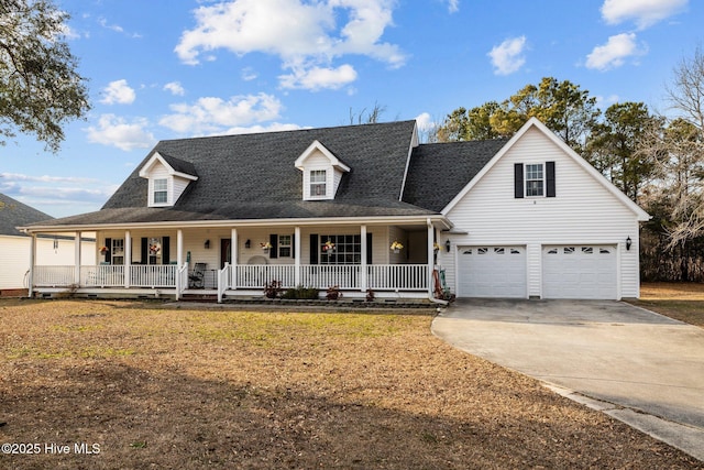 view of front facade with a porch, a front yard, concrete driveway, and an attached garage