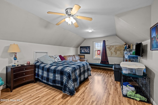 bedroom featuring vaulted ceiling, a baseboard radiator, wood finished floors, and a ceiling fan