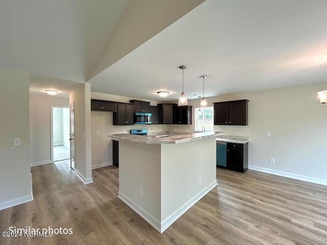 kitchen with baseboards, a kitchen island, appliances with stainless steel finishes, decorative light fixtures, and light wood-style floors