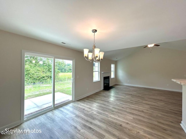 unfurnished living room with visible vents, a fireplace, baseboards, and wood finished floors