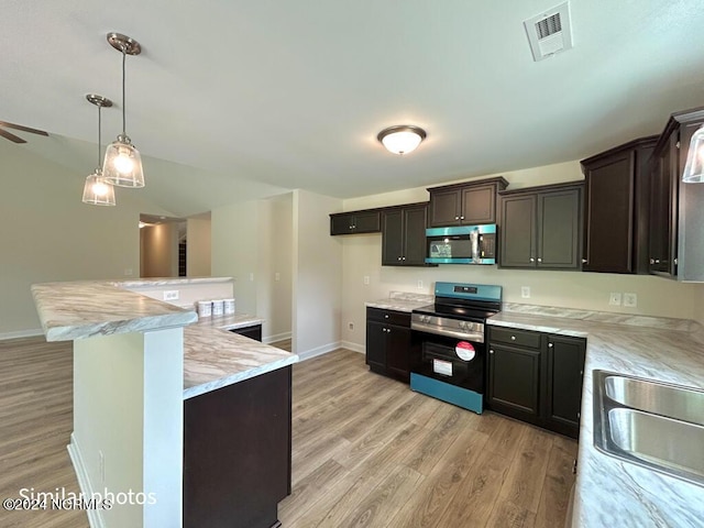 kitchen with visible vents, appliances with stainless steel finishes, a sink, light wood-type flooring, and baseboards