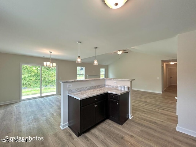 kitchen with lofted ceiling, light wood-style flooring, open floor plan, baseboards, and ceiling fan with notable chandelier