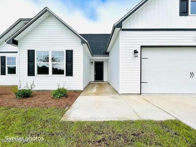 view of front of home featuring board and batten siding, roof with shingles, and driveway