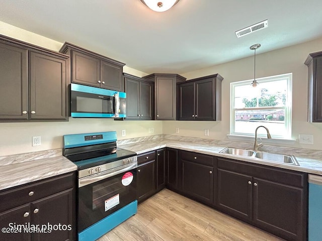 kitchen with visible vents, appliances with stainless steel finishes, light countertops, and a sink