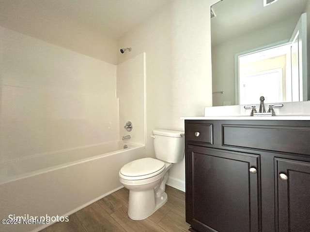 bathroom featuring vanity,  shower combination, wood finished floors, and toilet