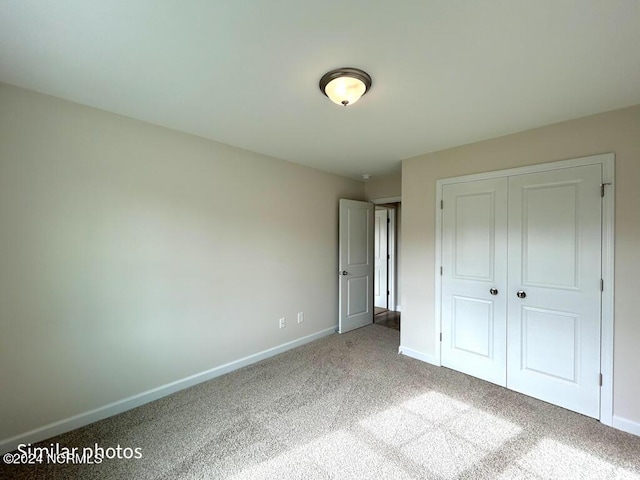 unfurnished bedroom with carpet, a closet, and baseboards