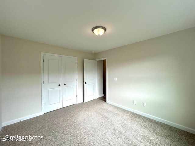 unfurnished bedroom with carpet, baseboards, and a closet