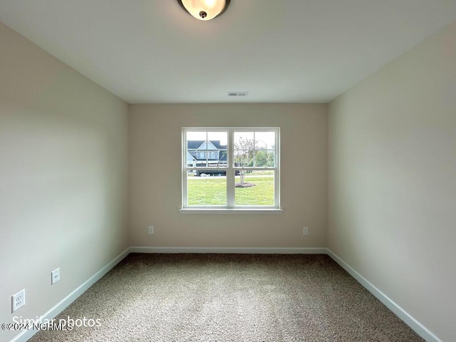 unfurnished room featuring baseboards, visible vents, and carpet flooring