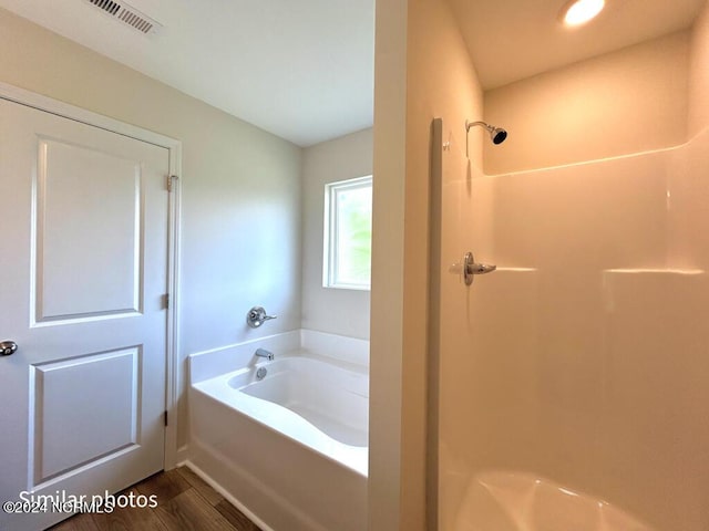 full bathroom with a garden tub, visible vents, a shower, and wood finished floors