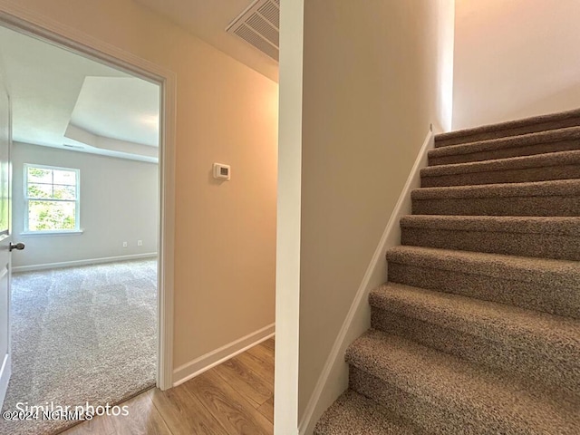 stairs featuring baseboards, visible vents, and wood finished floors