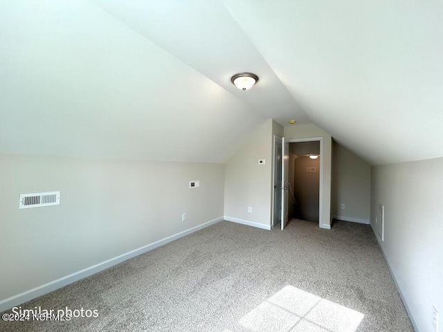 bonus room featuring lofted ceiling, carpet floors, baseboards, and visible vents