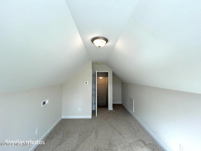 additional living space featuring carpet, visible vents, baseboards, and vaulted ceiling