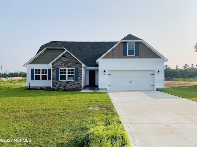 craftsman-style home with a garage, driveway, stone siding, board and batten siding, and a front yard