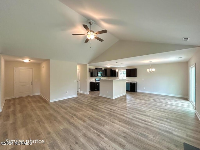 unfurnished living room with visible vents, baseboards, light wood-style flooring, high vaulted ceiling, and ceiling fan with notable chandelier