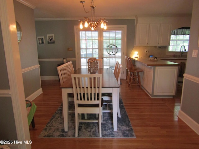 1426 Pocosin Rd, Winterville, NC 28590 - dining space featuring ornamental molding, a notable chandelier, a wealth of natural light, and wood finished floors