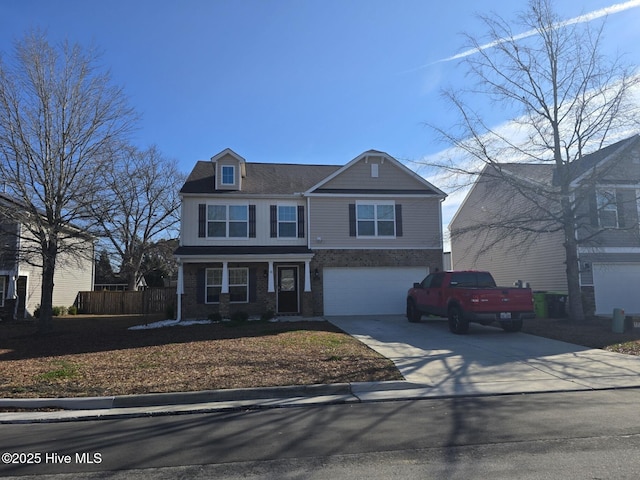 view of front of house with concrete driveway, fence, and an attached garage